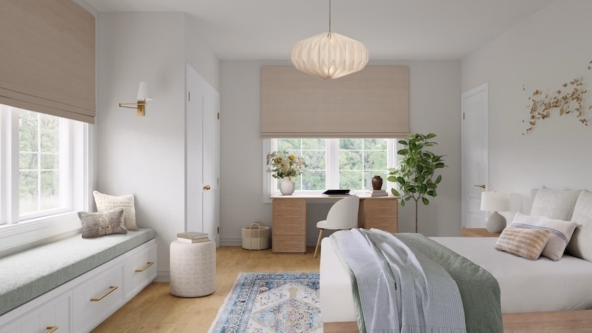 Latte blackout cotton Roman shades provide privacy above a desk in a bright, neutral bedroom.