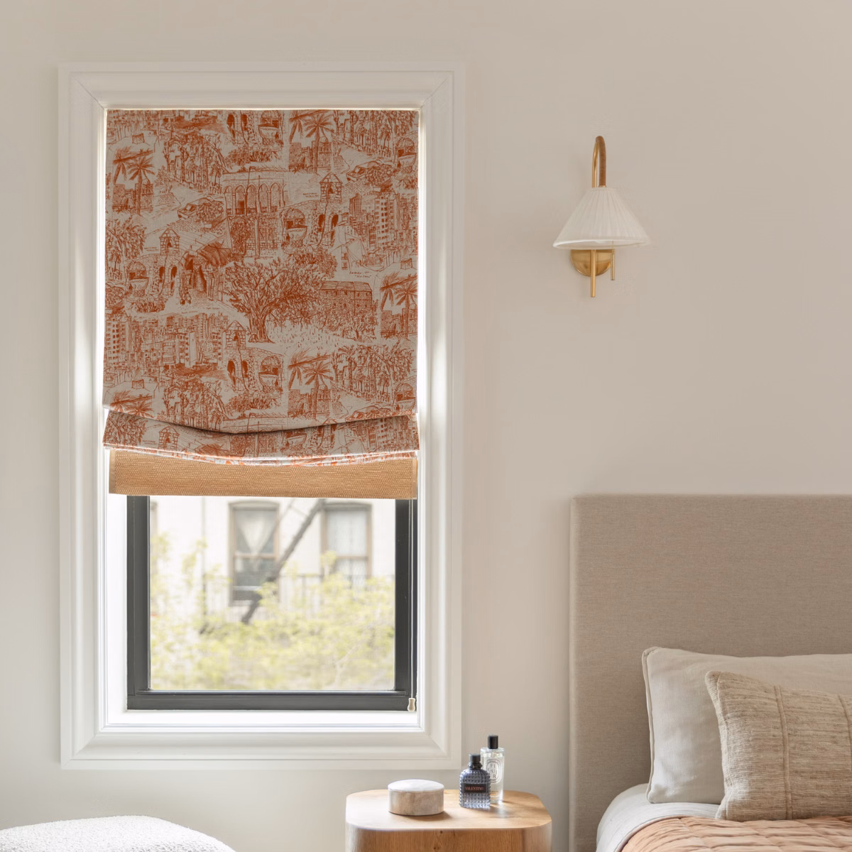 Inside mount Pays du Levant relaxed Roman shade adds warmth and privacy to a softly styled neutral bedroom.