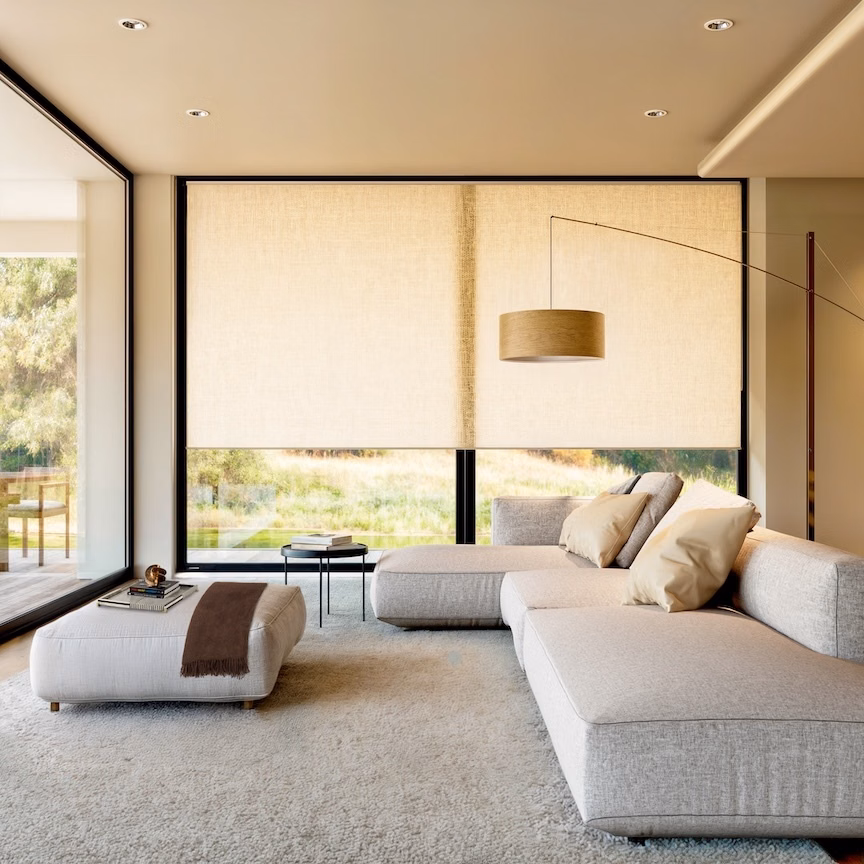 Nimbus white light-filtering roller shades soften sunlight across floor-to-ceiling windows in a modern neutral living room.