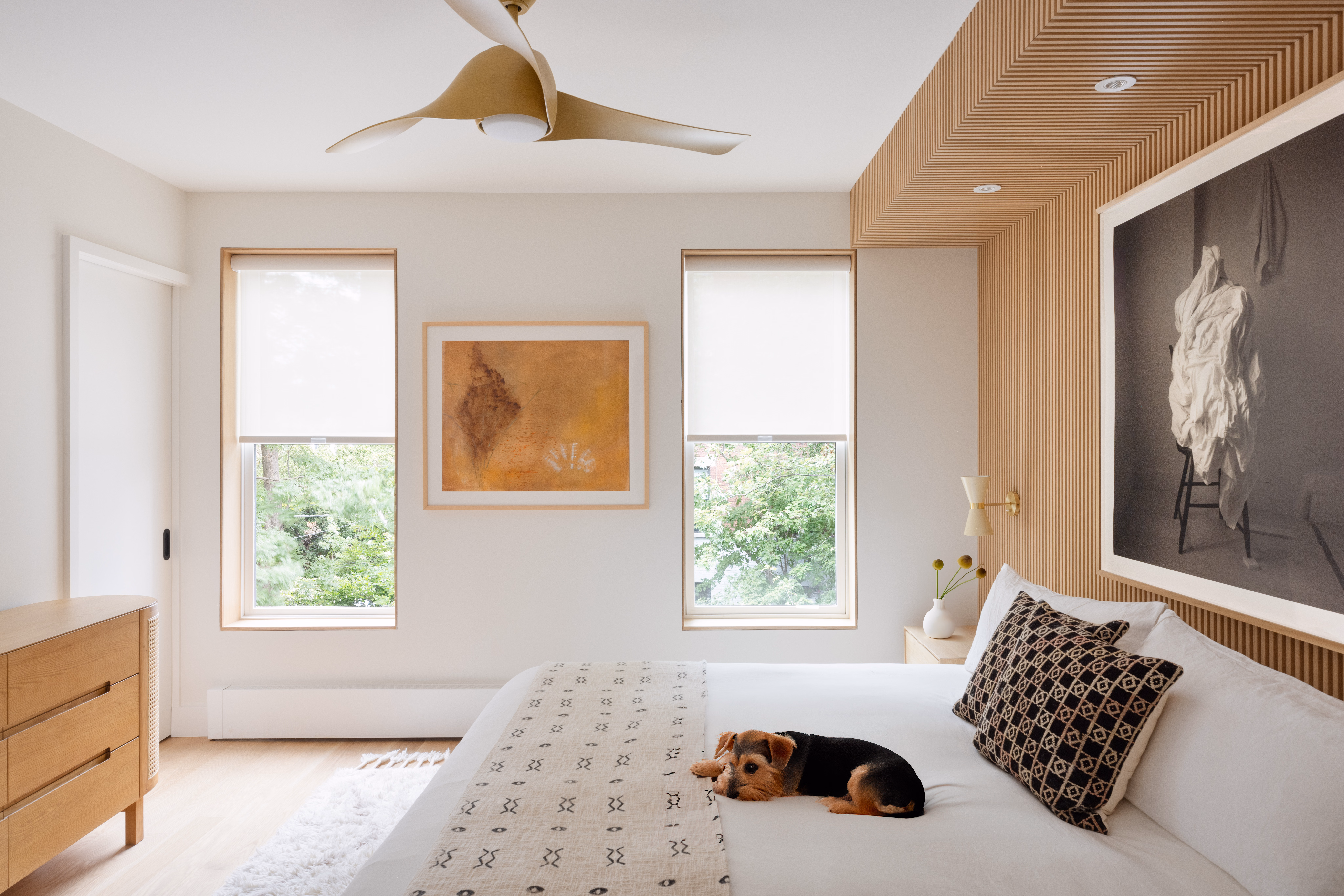 White light-filtering roller shades add soft privacy to a warm, modern bedroom with natural wood details.