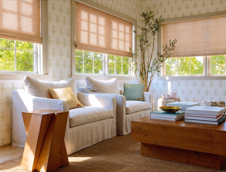 Grasscloth woven wood bottom-up shades filter sunlight and add privacy in a warm, layered living room.
