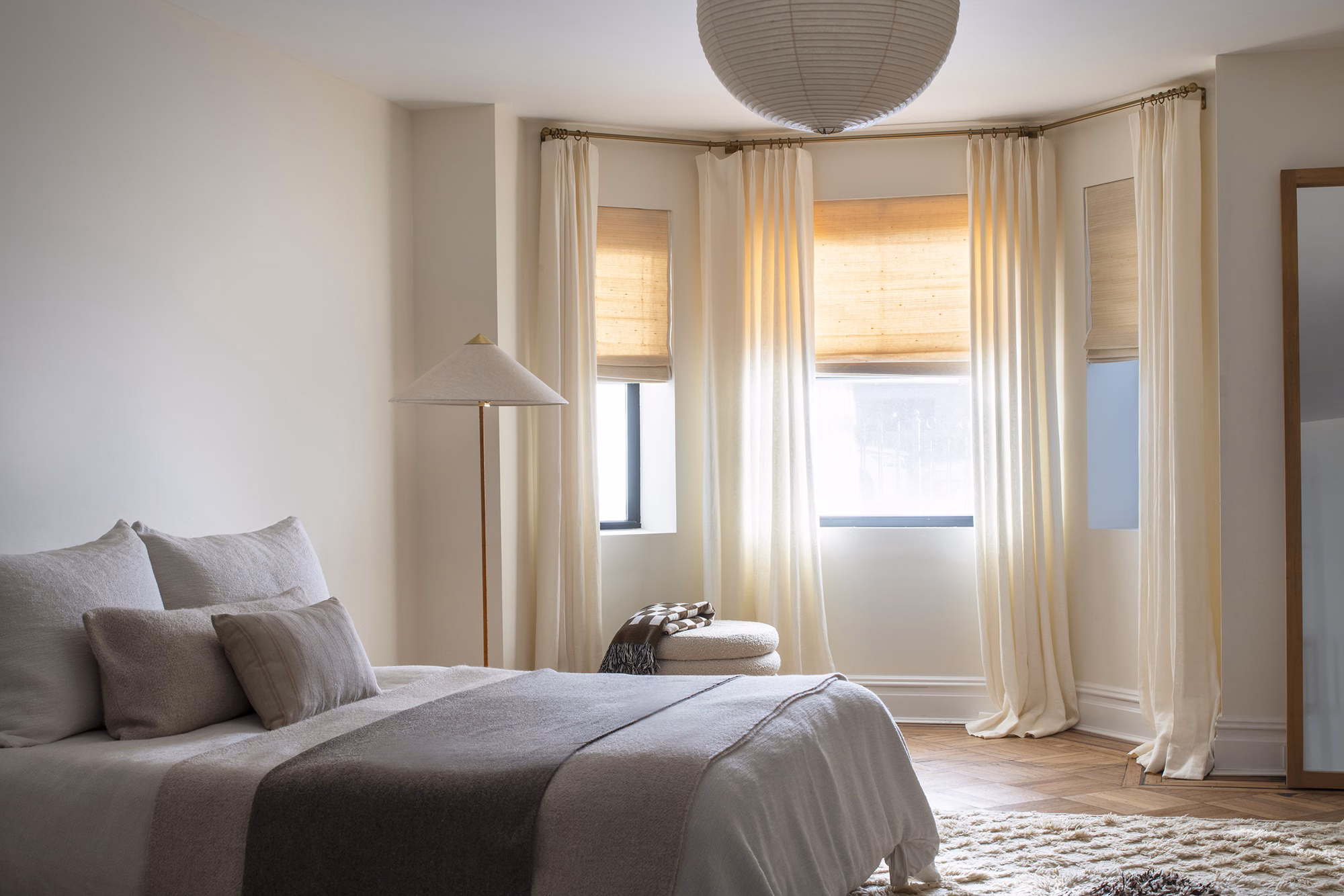 Luxury curtain rods with pinch pleat drapes in a bedroom