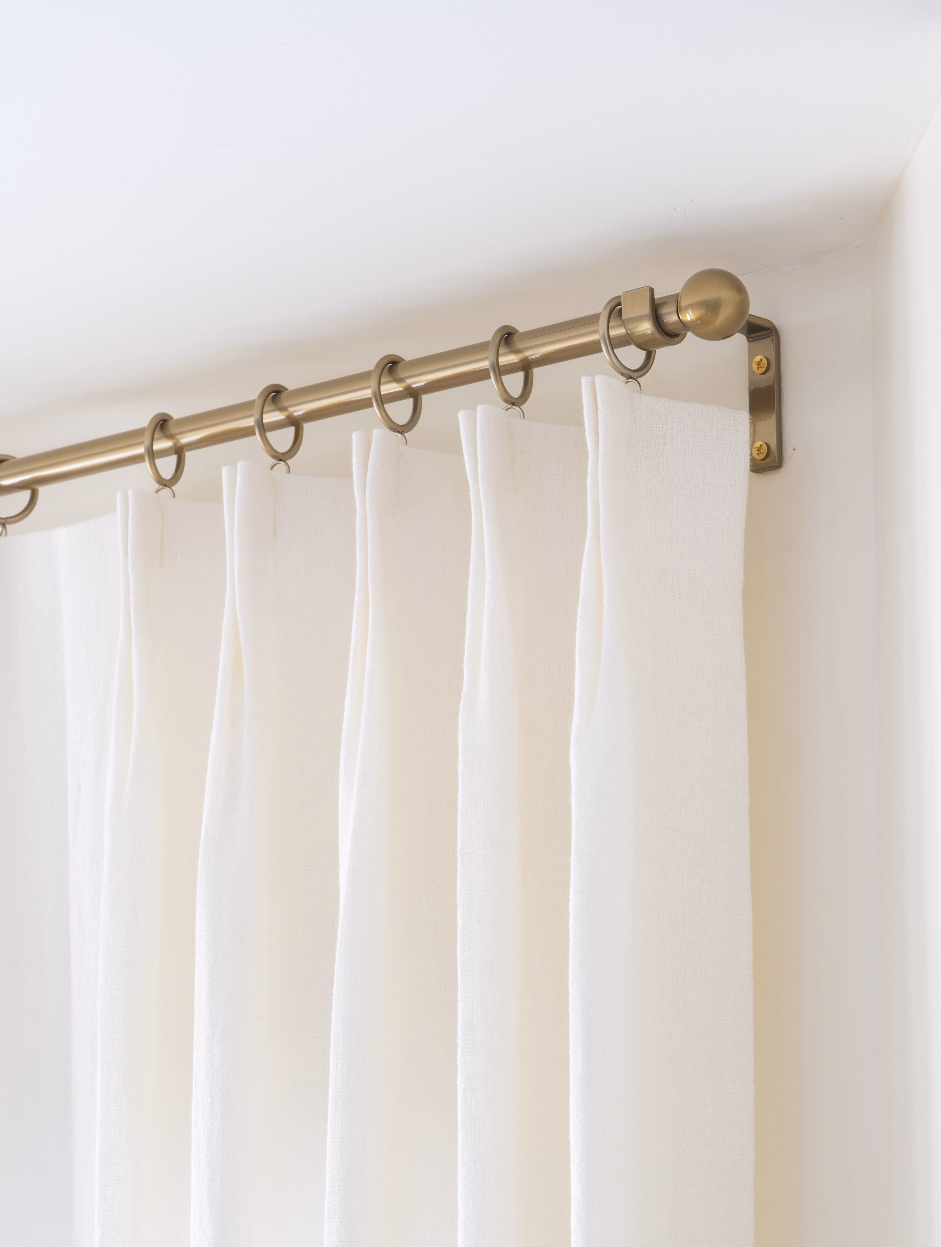 Custom brass rods with ball finial ends.